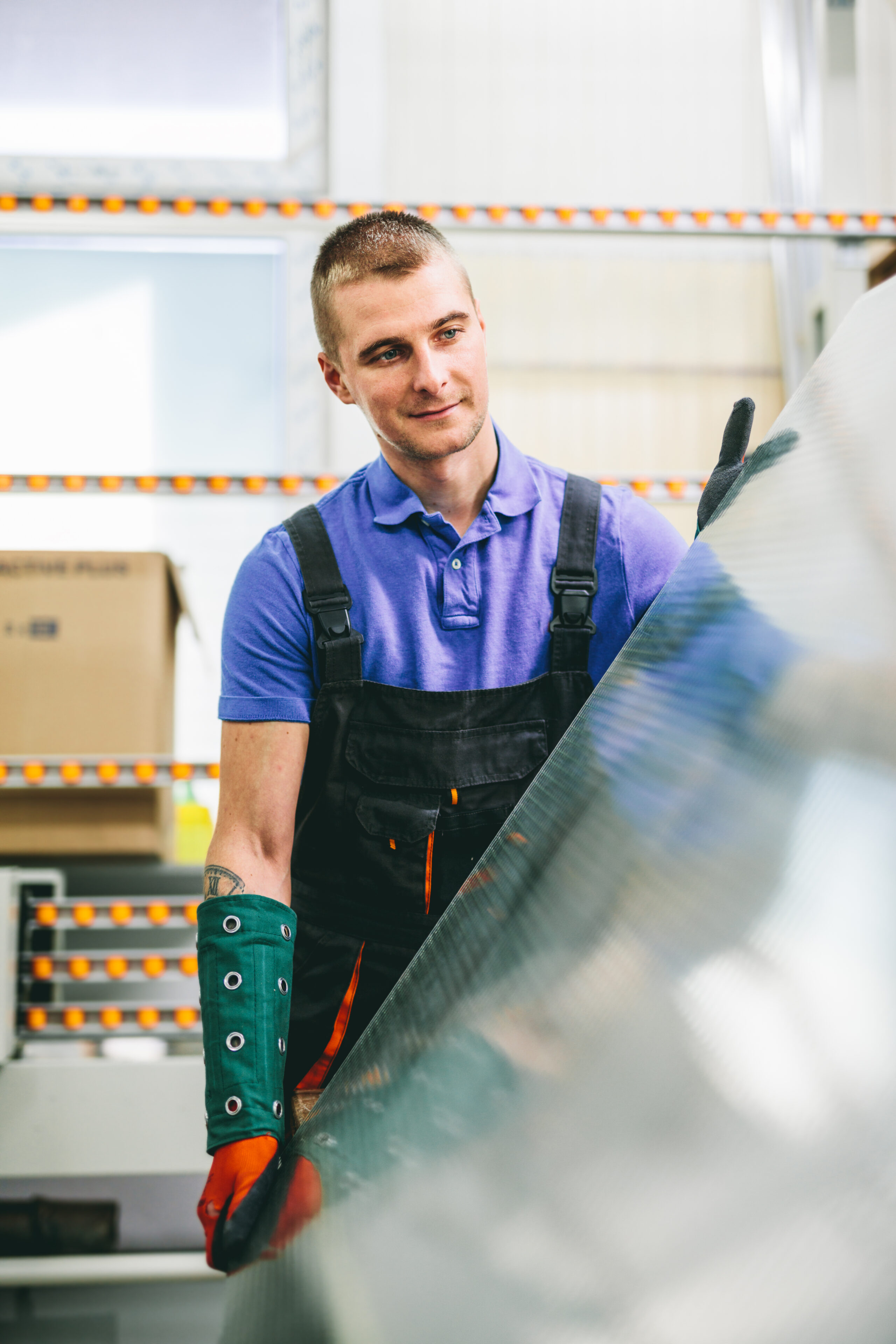 Glazier worker portrait with glass in workshop. Industry
